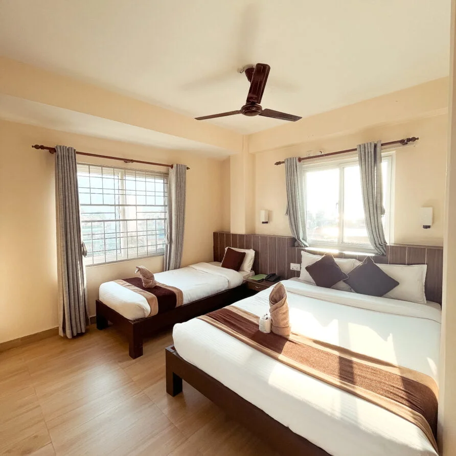 a room with two beds and a fan