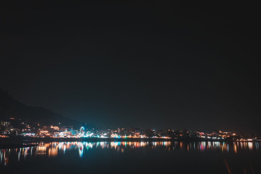 a city at night with lights reflecting on water