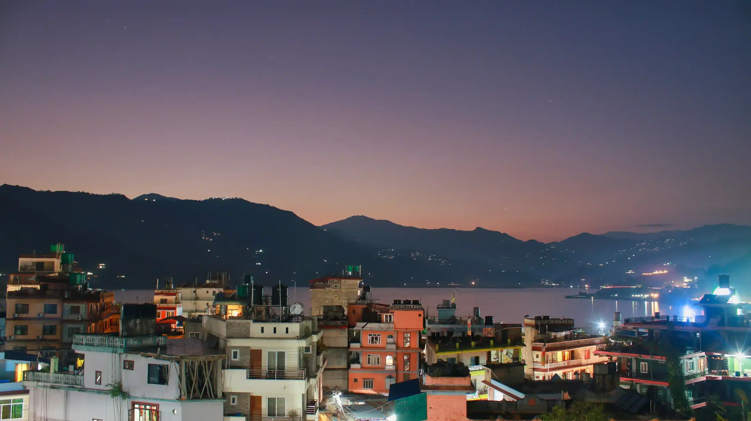 a city with buildings and mountains in the background